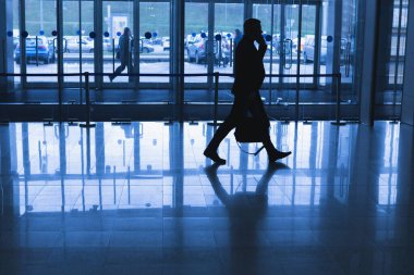 Modern cam bir binadaki bir iş adamının silüeti olan bir adam figürü. Soğuk bir arka ışık..