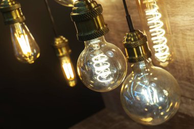 LED lambaları eski moda. Modern enerji tasarrufu ampulleri koyu bir arka planda asılı. Yakın plan..