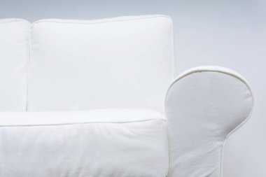 Beyaz arka planda beyaz bir kanepe parçası. Aydınlatılmış çerçevenin etkisi. Yakın plan..