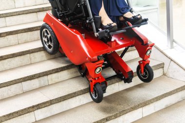 Motorlu bir tekerlekli sandalye merdivenlerden çıkıyor. Engelliler için mühendislerin modern gelişimi.