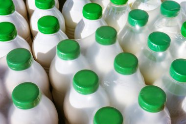 Polimer ambalajında süt olan plastik şişeler. Süt ürünleri toptan ticareti. Yukarıdan görüntüle