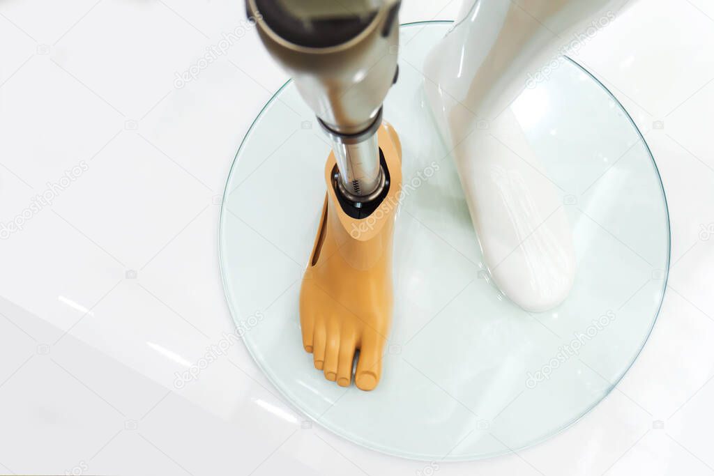 Metal prosthetic leg. Exhibition of modern prostheses. Prosthetics amputated limbs. Plastic mannequin on a stand. View from above.