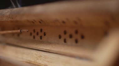 Tütsüden çıkan duman (aroma çubukları) eşsiz bir ahşap kutuda akar. Yakın plan. Sağa git. Tütsüye Odaklan.