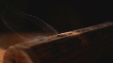 Duman eşsiz ahşap tütsü kutusundan çıkar (tütsü çubukları). Statik çerçeve. Duman kutu deliklerinden çıkıyor. Yakın plan. Dumana odaklan. Siyah arkaplan.