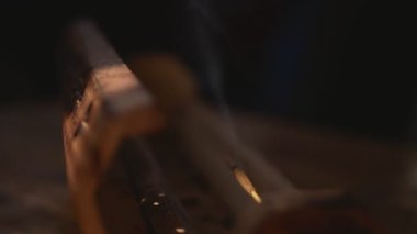 Tütsü, eşsiz bir ahşap kutudan tütsülenir. Döngüsel yarım dönüş. Kutu ışığa gider ve karanlığa gider. Sağlığa ve dumana odaklan. Siyah arkaplan.
