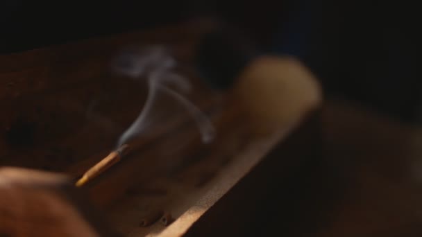 Des couches de fumée s'écoulent d'une boîte d'encens en bois unique, d'un cadre statique, d'un gros plan. Focus sur l'encens et la fumée.
