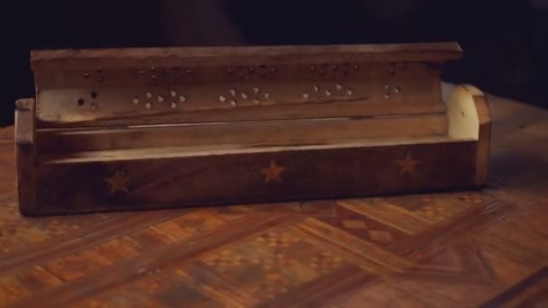 Encens en bois unique (bâtonnets d'encens) boîte avec une étoile tourne sur une table faite à la main. Cycle. tourne dans le sens horaire. Fond noir