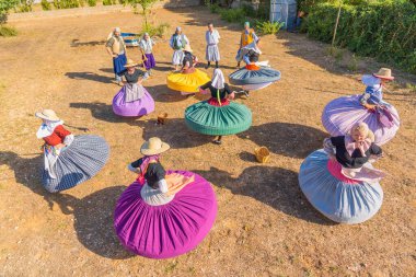 Mallorca, boleros, balo de bot, geleneksel Mallorcan dans grubu el yapımı kıyafetleriyle yukarıdan çekilmiş bir tarlada prova yapıyorlar.