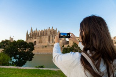 Palma de Mallorca katedralinin resmini çeken genç, açık tenli bir kız..