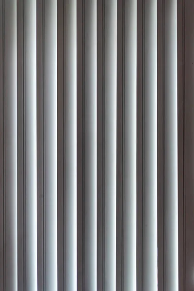 Vertical window blinds. Real blind curtains. Striped background with silver jalousie