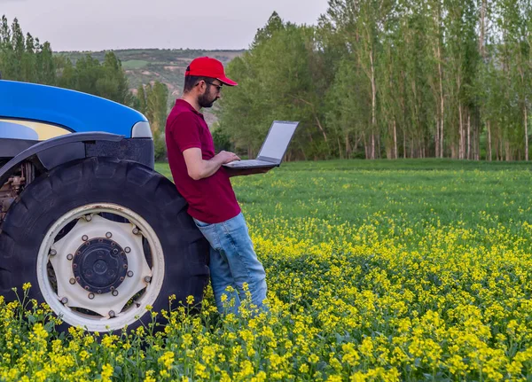Smart farming argriculture concept. Man hands holding computer on blurred organic farm as background.  smart irrigation technology. american farmer