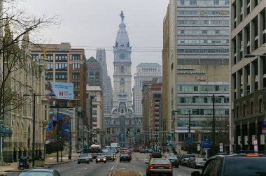 Philadelphia 'daki Broad Caddesi' nde sis ve trafik ve arka plandaki belediye kulesi, Pennsylvania, ABD