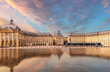 Place de la Bourse ve Gironde, Yeni Aquitaine, Fransa 'daki Bordeaux' daki yansıtma havuzundan geçen bir tramvay.