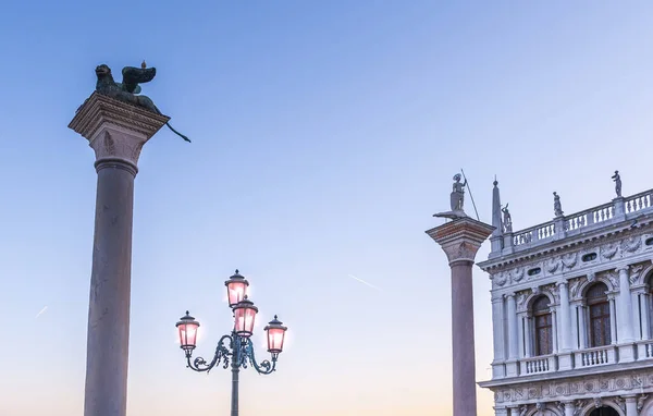 The Columns of Piazzetta - Saint Mark and Saint Theodore and a lamppost in Saint Mark\'s square in the early morning in Venice in Veneto, Italy