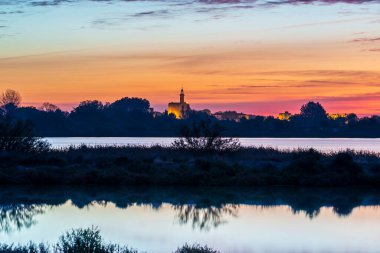 Ortaçağ Aigues-Mortes şehrinin tahkimatlarının Constance kulesi Marette göletinden gün doğumunda, Gard 'da, Fransa' nın Occitania şehrinde.