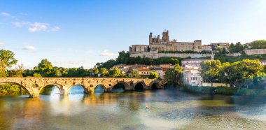 Fransa 'nın Occitanie kentindeki Bziers' deki Orb Nehri üzerindeki eski köprü ve Saint-Nazaire katedrali.