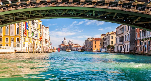 The Grand Canal under the Academy walkway and the boat traffic and the Basilica of Santa Maria della salute in the background in Venice in Veneto, Italy