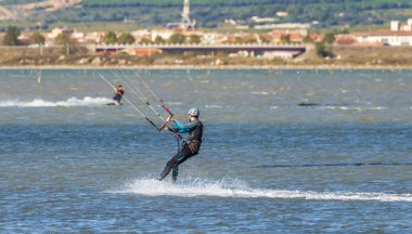 Frontignan 'da, Herault' da, Occitania 'da, Fransa' da Ingril gölünde uçurtma uçuran bir adam.