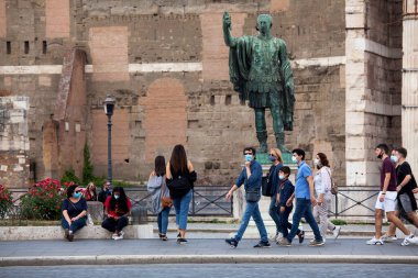 Roma, İtalya - Haziran 02 2020 İtalya yeniden açılıyor, 3. aşamaya başlayın. Roma, İtalya 'da Colosseum (Colosseo) yakınlarındaki Fori Imperiali caddesinde koruyucu maskeler takan insanlar yürüyor