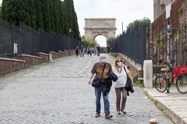 Roma, İtalya - Haziran 02 2020 İtalya yeniden açılıyor, 3. aşamaya başlayın. Roma, İtalya 'da Colosseum (Colosseo) yakınlarındaki Fori Imperiali caddesinde koruyucu maskeler takan insanlar yürüyor