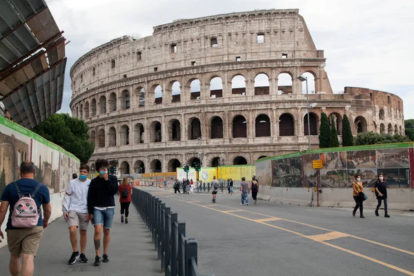 Roma, İtalya - Haziran 02 2020 İtalya yeniden açılıyor, 3. aşamaya başlayın. Roma, İtalya 'da Colosseum (Colosseo) yakınlarındaki Fori Imperiali caddesinde koruyucu maskeler takan insanlar yürüyor