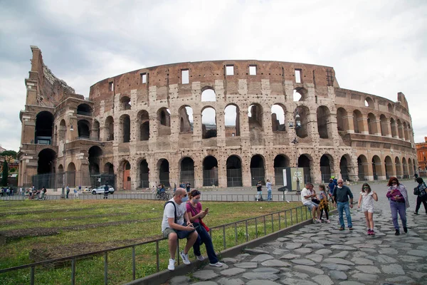 Roma, İtalya - Haziran 02 2020 İtalya yeniden açılıyor, 3. aşamaya başlayın. Roma, İtalya 'da insanlar koruyucu maskeler takıp Colosseum (Colosseo) yakınlarında yürüyor ve oturuyorlar.