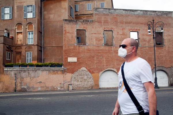 Roma, İtalya - Haziran 02 2020 İtalya yeniden açılıyor, 3. aşamaya başlayın. Kolezyum (Colosseo) yakınlarında Fori Imperiali caddesinde yürüyen koruyucu maskeli bir adam var.