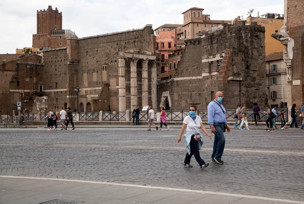 Roma, İtalya - Haziran 02 2020 İtalya yeniden açılıyor, 3. aşamaya başlayın. Roma, İtalya 'da Colosseum (Colosseo) yakınlarındaki Fori Imperiali caddesinde koruyucu maskeler takan insanlar yürüyor