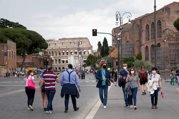 Roma, İtalya - Haziran 02 2020 İtalya yeniden açılıyor, 3. aşamaya başlayın. Roma, İtalya 'da Colosseum (Colosseo) yakınlarındaki Fori Imperiali caddesinde koruyucu maskeler takan insanlar yürüyor