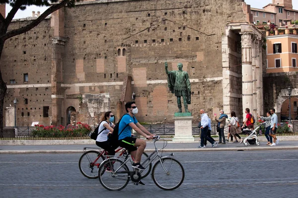 Roma, İtalya - Haziran 02 2020 İtalya yeniden açılıyor, 3. aşamaya başlayın. Roma, İtalya 'da Colosseum (Colosseo) yakınlarındaki Fori Imperiali caddesinde koruyucu maskeler takan insanlar yürüyor