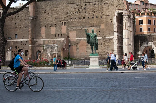 Roma, İtalya - Haziran 02 2020 İtalya yeniden açılıyor, 3. aşamaya başlayın. Roma, İtalya 'da Colosseum (Colosseo) yakınlarındaki Fori Imperiali caddesinde koruyucu maskeler takan insanlar yürüyor