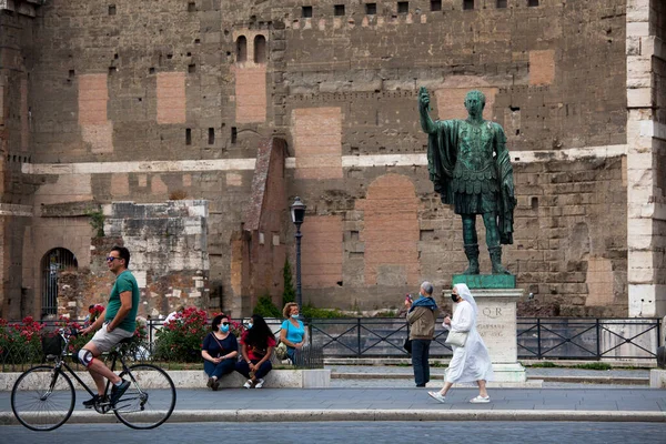 Roma, İtalya - Haziran 02 2020 İtalya yeniden açılıyor, 3. aşamaya başlayın. Roma, İtalya 'da Colosseum (Colosseo) yakınlarındaki Fori Imperiali caddesinde koruyucu maskeler takan insanlar yürüyor