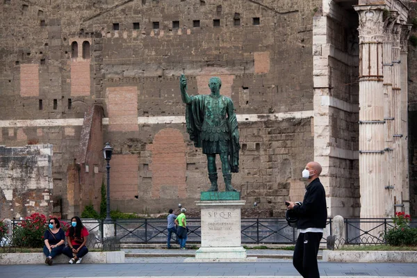 Roma, İtalya - Haziran 02 2020 İtalya yeniden açılıyor, 3. aşamaya başlayın. Roma, İtalya 'da Colosseum (Colosseo) yakınlarındaki Fori Imperiali caddesinde koruyucu maskeler takan insanlar yürüyor