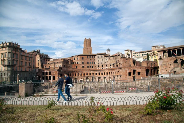 Roma, İtalya - Haziran 02 2020 İtalya yeniden açılıyor, 3. aşamaya başlayın. Roma, İtalya 'da Colosseum (Colosseo) yakınlarında Fori Imperiali caddesinde yürüyen koruyucu maskeli bir çift görülüyor.
