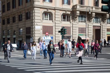 ROME, İTALYA - 01.01.2020 Koruyucu yüz maskeleri takan banliyö sakinleri, Roma, İtalya 'da karşıya geçtiler..