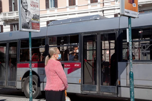 ROMA, İtalya - 01.2020 Koruyucu yüz maskesi takan bir yolcu İtalya, Roma 'da bir otobüsün içinde oturuyor.