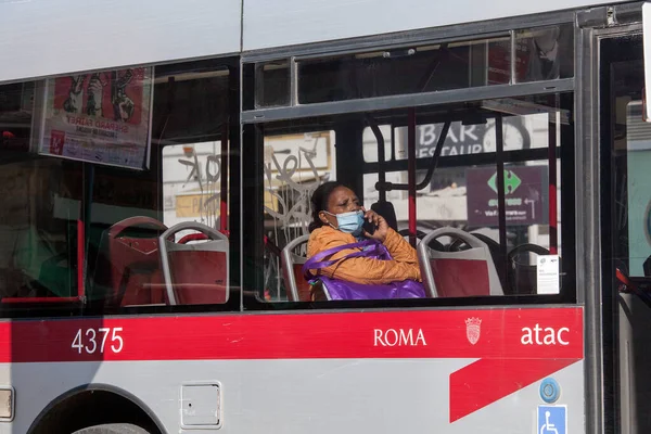 ROMA, İtalya - 01.2020 Koruyucu yüz maskesi takan bir yolcu İtalya, Roma 'da bir otobüsün içinde oturuyor.