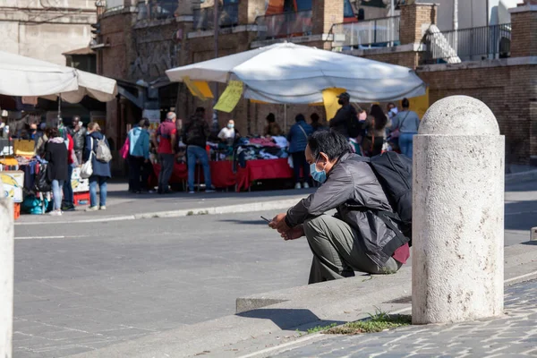 ROMA, İtalya - 01.01.2020 Koruyucu yüz maskeleri takan yaya Roma, İtalya 'da bankta oturuyor..