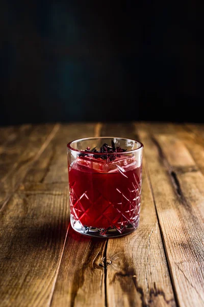 Ein Hibiskuscocktail Mit Einem Eiswürfel Steinglas Auf Einem Holztisch — Stockfoto