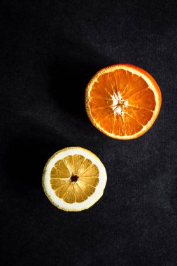 Koyu gri arka planda portakal ve limon kesiminin en üstteki fotoğrafı.