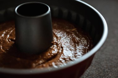 Çikolata hamuruyla dolu bir kek kalıbının kırpılmış yatay fotoğrafı.