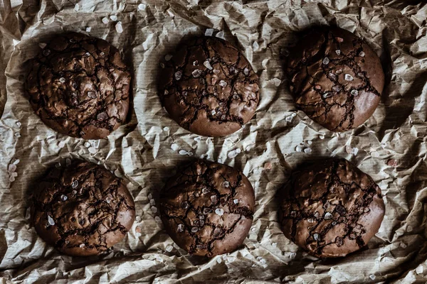 黒を基調としたクラフト紙に海塩で割れたトップとチョコレートクッキー 上からの眺め — ストック写真