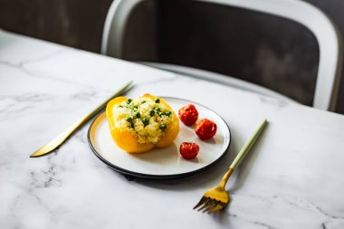 Kuskus, yeşil bezelye, peynir ve vişneli domatesle doldurulmuş fırında sarı biber.