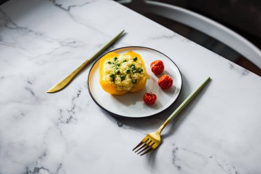 Kuskus, yeşil bezelye, peynir ve vişneli domatesle doldurulmuş fırında sarı biber.