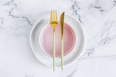 Beyaz mermer zemin üzerinde seramik plakalar ile zarif tablo ayarı, üst görünüm