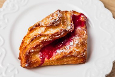 Beyaz tabakta kırmızı reçelli puf böreği