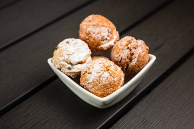 Beyaz kasede pudra şekerle kaplı küçük yuvarlak kurabiyeler.