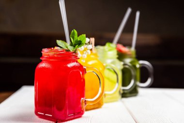 Kavanozlarda 4 farklı ferahlatıcı yaz limonatası, kırmızı, turuncu, sarı ve yeşil