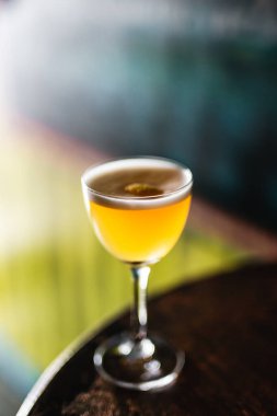 Çentikte ekşi bir kokteyl ve köpüklü portakal kabuğuyla Nora bardağı.