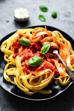 Arrabbiata soslu Tagliatelle makarnası, fesleğen, sarımsak, vişneli domates.